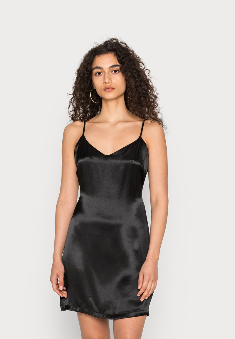 Vestido slip preto em satin com alças finas, decote em V e uma textura suave. Apresenta uma barra reta e uma silhueta ajustada.
