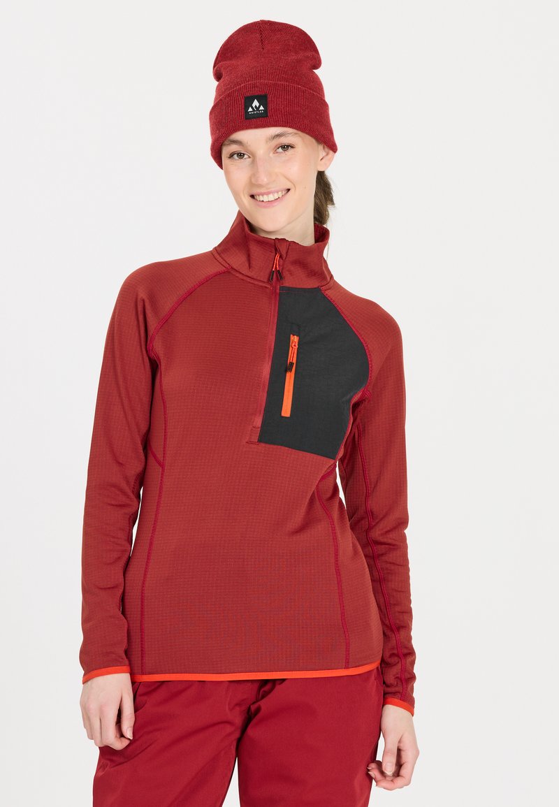 Roter Pullover mit langen Ärmeln und einem Halb-Reißverschluss-Kragen, schwarzer Brusttasche und orangefarbenen Reißverschlussdetails. Glatte Textur mit kontrastierenden Nähten.