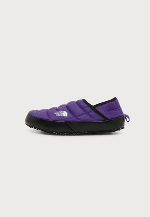 Lilla quiltet slip-on sko med sort sål og "The North Face" logo på siden, designet til afslappet eller indendørs brug.