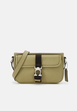 Vihreä nahkainen olkalaukku, jossa on teksturoitu pinta, säädettävä hihna, musta kangasaccentti ja hopeiset yksityiskohdat.