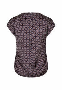 Blouse à manches courtes avec un motif géométrique de cercles superposés en bleu marine, rose et blanc sur un fond sombre.