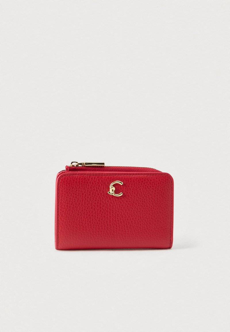 Červená текстurální kožená peněženka se zlatým zipem a malým zlatým logem na přední straně, umístěná na jednolitém světlém pozadí.