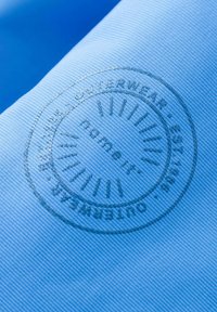Light blue fabric with a textured surface features a circular, embossed logo in a darker shade. The design includes sunray accents.