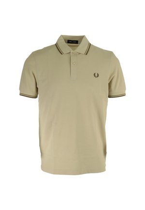 Polo shirt beige en coton, avec une patte de boutonnage à deux boutons, des rayures marron contrastantes sur le col et les manches, et un logo brodé.