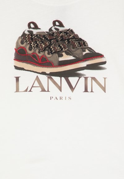 Grafikos marškiniai su sportinėmis bateliais, kurie turi kamufliažo raštą, rudus raiščius, raudonus akcentus ir tekstą "LANVIN PARIS" po jais.
