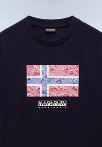 Námořnická modrá bavlněná trička s texturovaným, stylizovaným designem norské vlajky v červené, bílé a modré barvě, s textem "NAPAPIJRI geographic" pod ním.