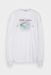 Ljusgrå långärmad t-shirt i bomull med rund halsringning. Har grafisk text och en diamantlogotyp i iriserande färger.