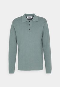 Polo à manches longues vert menthe en tissu texturé, doté d'un col, d'une patte à trois boutons et d'un design minimaliste.