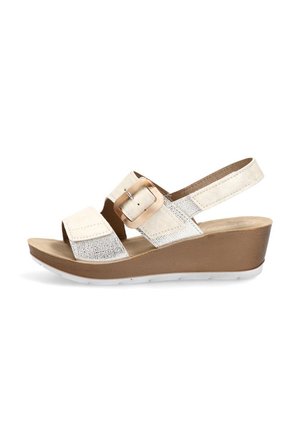 Sandalia cuña beige con dedos abiertos, tiras anchas, una hebilla grande y una suela marrón, diseñada para uso casual.