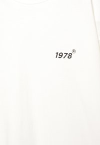 Hvid bomulds t-shirt med rund halsudskæring, der har en sort trykt tekst "1978" og et registreret varemærkesymbol.