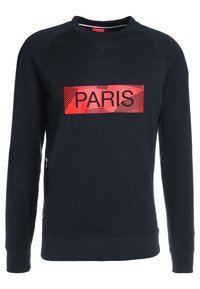 Felpa blu con grafica rossa "PARIS" sulla parte anteriore. Presenta un collo girocollo a costine e tasche laterali con zip. Tessuto morbido e texturizzato.