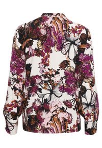 Blusa de manga larga en color crema con un vibrante estampado floral en púrpura, rosa y negro. Presenta un corte relajado y detalles de botones en los puños.