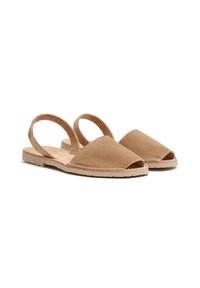 Sandalias tipo slingback de ante en tono claro, con punta abierta, suela plana y detalle de costura en contraste en los bordes; diseño minimalista y textura suave.