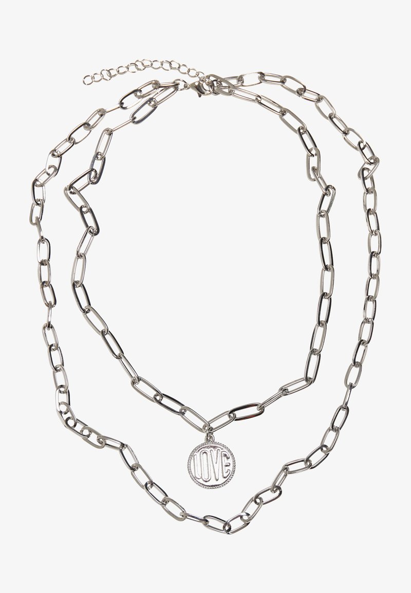 Hõbedane kettkaelakee, millel on piklikud lingid ja ümmargune ripats, millel on graveeritud sõna "ARMASTUS" ning tekstuuriga äär.