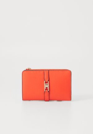 Portefeuille orange vif en matériau lisse, avec un fermoir en métal doré et des bordures noires. Forme rectangulaire avec une fermeture éclair.