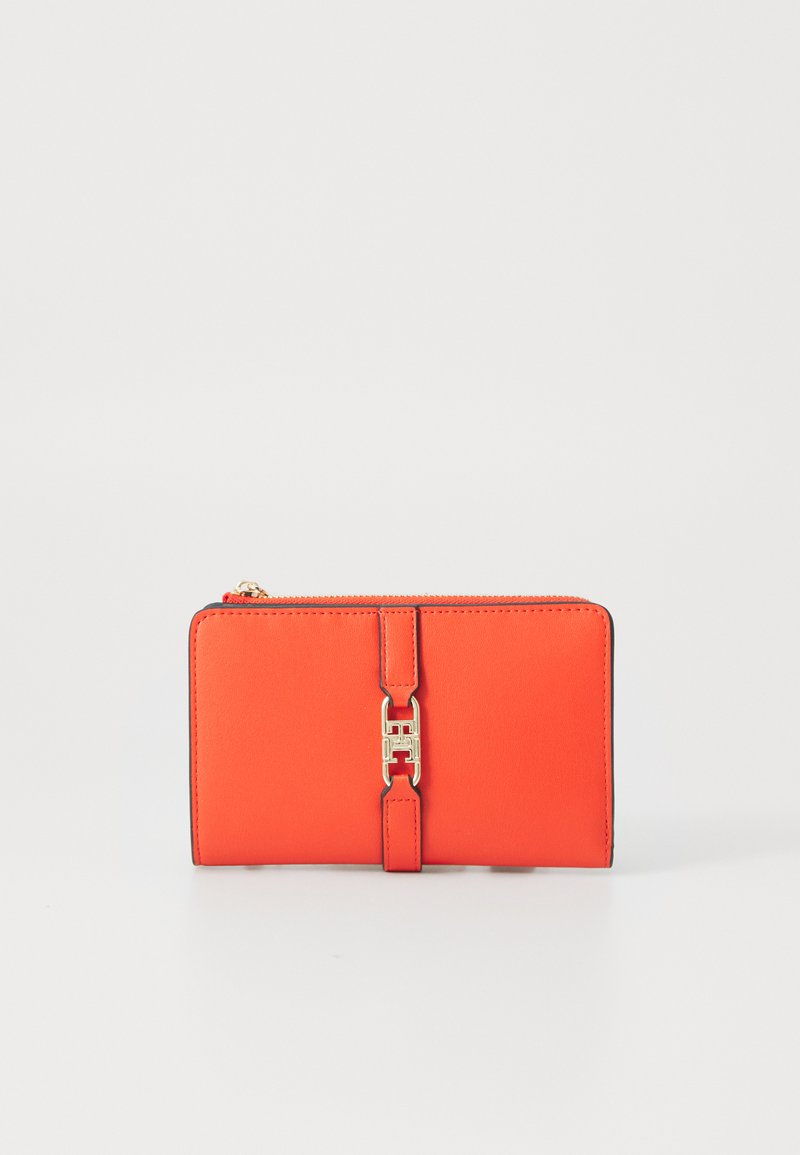 Bright orange wallet made of smooth material, featuring a gold accent clasp and black trim. Rectangular shape with a zip closure.