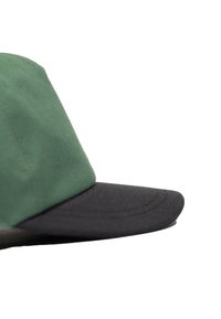 Grüne Stoffmütze mit einem schwarzen Schirm, die ein strukturiertes Design und eine glatte Textur aufweist, mit klaren Linien und einer minimalistischen Ästhetik.