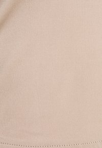 Beige textile with a smooth, slightly textured surface. Fabric has a consistent pattern of fine ribs and a neat, stitched hem.