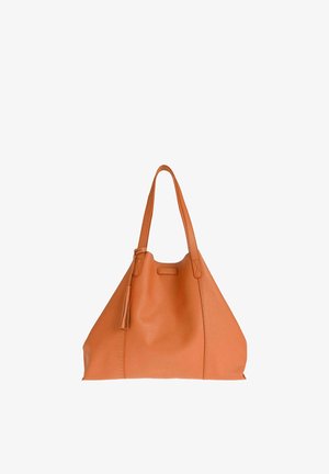 Sac cabas en cuir fauve avec deux bretelles et un détail pompon, avec une petite étiquette de marque embossée à l'avant.