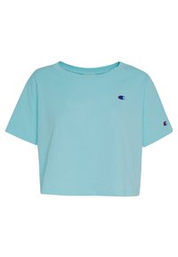 Camiseta recortada de color azul claro con mangas cortas, que presenta pequeños logotipos bordados de Champion en el pecho y en la manga izquierda.