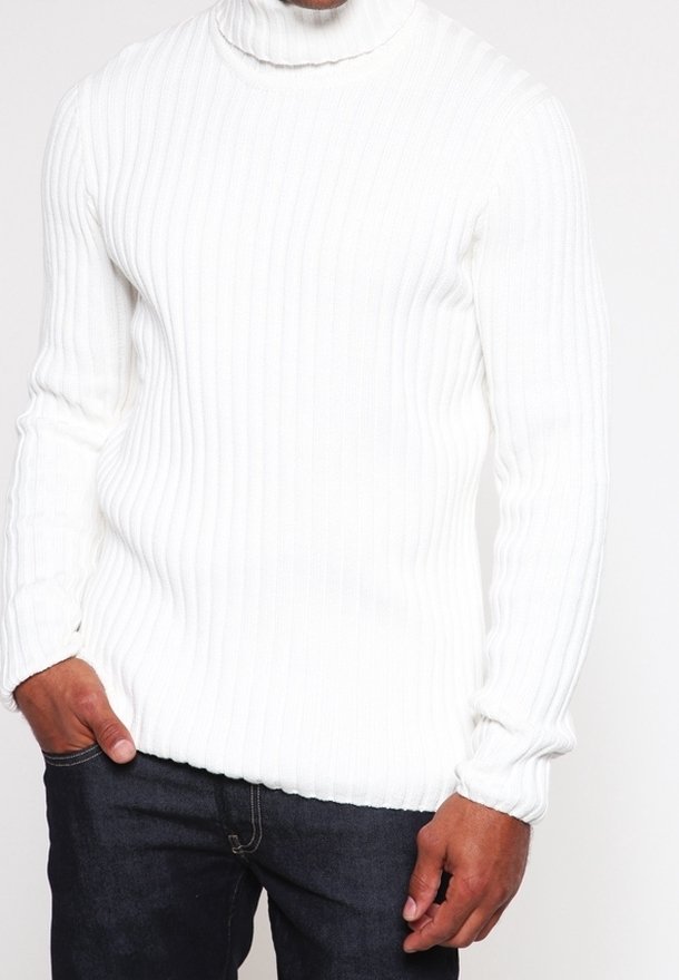 Vit ribbad stickad turtleneck-tröja med långa ärmar, med en figurnära silhuett och textilstruktur. Matchad med mörka jeans.