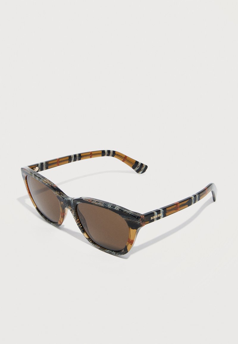 Lunettes de soleil avec des verres teintés marron et une monture à carreaux marron, noir et ambre, arborant le logo Burberry sur les branches.