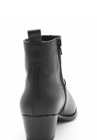 Stivaletto in pelle nera con chiusura a zip sul lato, punta rotonda, tacco quadrato corto e dettagli cuciti sul retro.