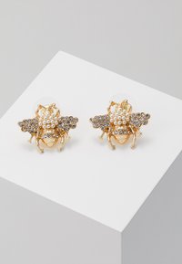 Orecchini a forma di ape in tonalità oro, con accenti di perle e cristalli, caratterizzati da dettagli intricati e una finitura lucida per un aspetto texturizzato.