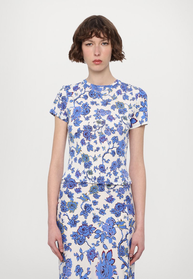 Short-sleeve floral top in white, featuring blue and green floral patterns. Made of lightweight fabric with a round neckline and slim fit.