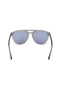 Gafas de sol con montura de plástico transparente gris y lentes reflectantes azules, con un diseño minimalista y patillas rectas.