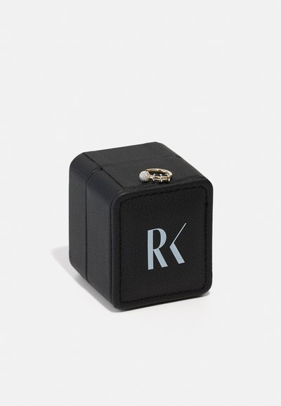 Black leather ring box with a smooth texture, featuring a silver-tone clasp and embossed logo "RK" in light blue. Square shape, compact design.