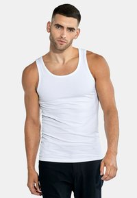Weißes Baumwoll-Tanktop mit rundem Ausschnitt und weitem Armloch, das eine glatte Textur und eine enganliegende Passform aufweist. Keine Muster oder Akzente.