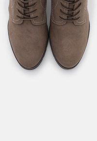 Bruine suède schoenen met een ronde neus, met een vetersluiting, contrasterende stiksels en een gestructureerde zwarte zool.