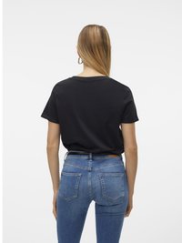 Svart bomull T-skjorte med avslappet passform, paret med blå denim skinny jeans som har baklommer og en lap på midjen.