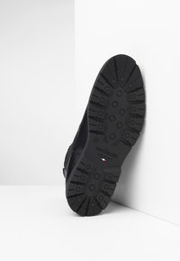 Scarpa nera in pelle con suola in gomma dalla texture e grip stampato; contrassegnata con "NeroGiardini" e "Made in Italy" sulla suola.