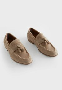 Mocassini beige con tomaia in suede e intrecciata, dotati di un frangia decorativa, cuciture a contrasto e una suola bassa e resistente.