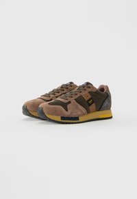 Pair of brown and olive green suede sneakers with rubber soles and branded side patch, laced up, displayed on white background.