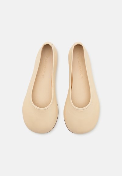 Ballerines en cuir beige avec un bout rond, une texture lisse et une ouverture élastiquée. Design minimaliste avec une semelle plate.