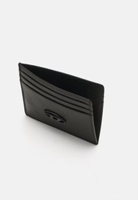 Tarjetero de cuero negro con múltiples ranuras para tarjetas, superficie texturizada y un detalle de diseño con corte central. Forma compacta y vertical.