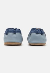 Weiche, blaue Leder-Schlupfschuhe mit einem dunkleren blauen Rüschendetail. Die Sohle hat ein strukturiertes, tanfarbiges Finish für besseren Halt.