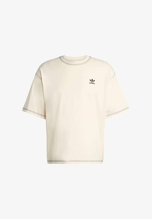 Cream-colored oversized t-shirt made of cotton, features short sleeves, crew neckline, and black Adidas logo on the left chest.