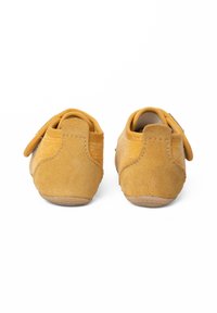 Scarpe marroni con una combinazione di scamosciato e tessuto texturizzato, forma rotonda, cinturini posteriori e suole in gomma flessibili. Nessun motivo o accentuazione particolare.