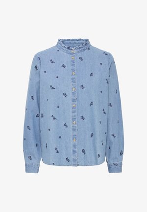 Lys blå denimskjorte med lange ærmer, flæset krave og små mørke blomsterprints. Har knaplukning foran.