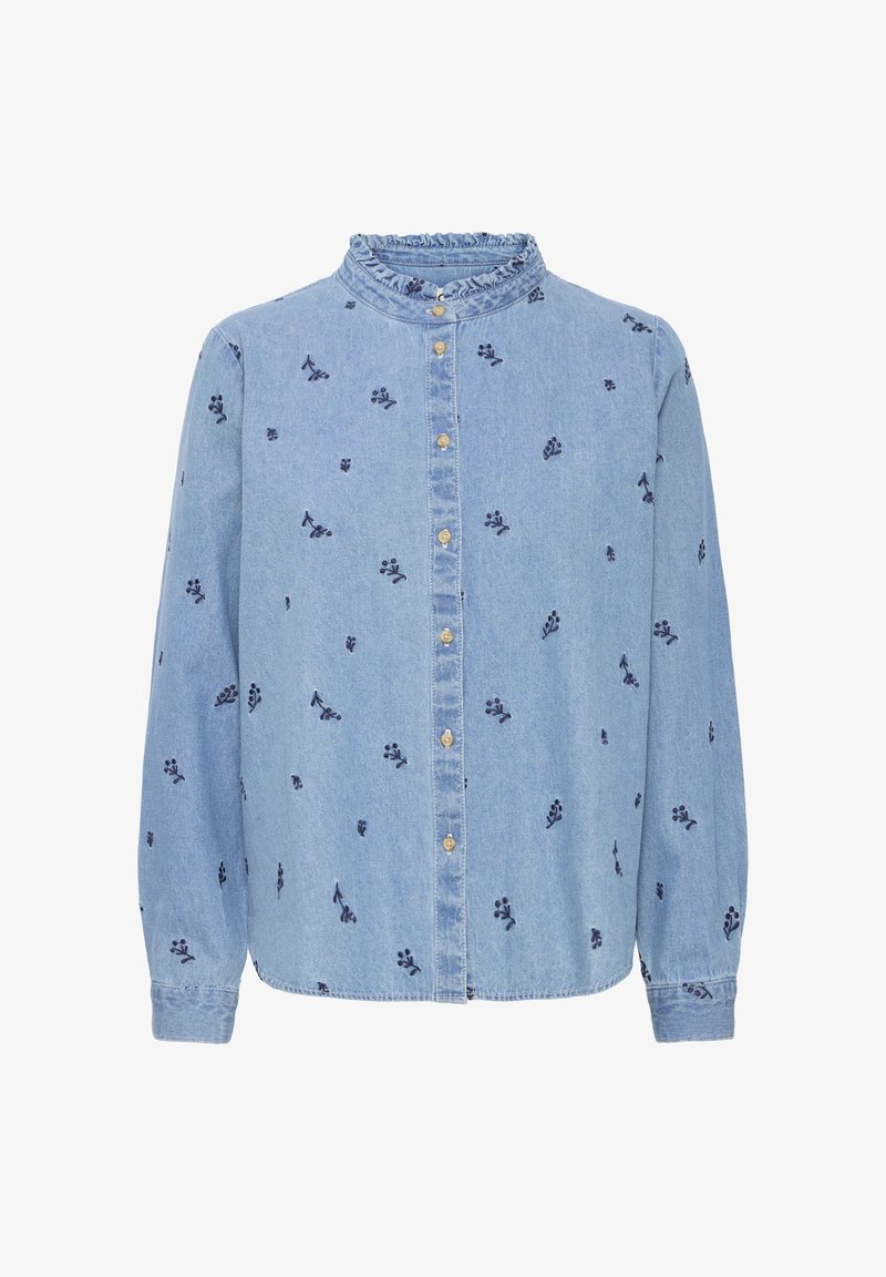 Chemise en denim bleu clair à manches longues, avec un col volanté et un petit motif floral foncé. Fermeture à boutons sur le devant.