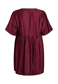 Burgundin mekko, jossa on lyhyet hihat ja rypytetty vyötärö. Mekossa on tekstuurinen kangas ja virtaava siluetti, nähtynä takaa.