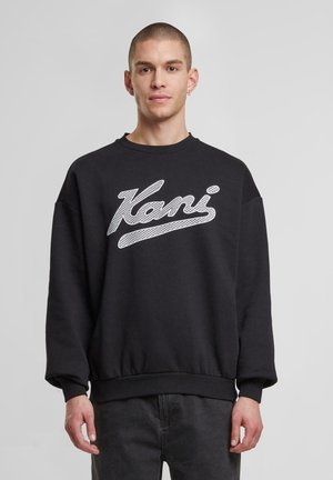 Black sweatshirt made from textured fabric featuring a white, stylized text logo on the front, with a crew neck and ribbed cuffs.