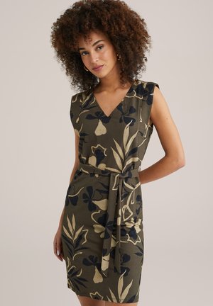 Robe sans manches en vert olive avec des motifs floraux beige et marine. Présente un décolleté en V et une ceinture en tissu assorti pour un ajustement ajustable.