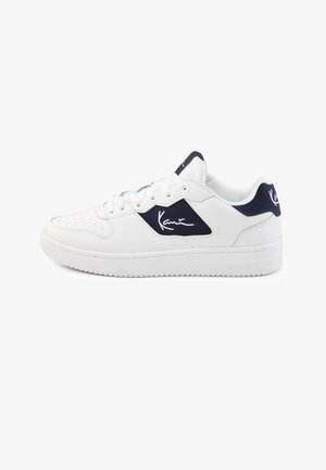 White low-top sneaker with navy accents and signature logo on side and heel, perforated toe, and lace-up closure.