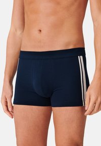 Boxer in cotone morbido di colore navy, con due strisce verticali bianche sui lati e un ampio elastico in vita.