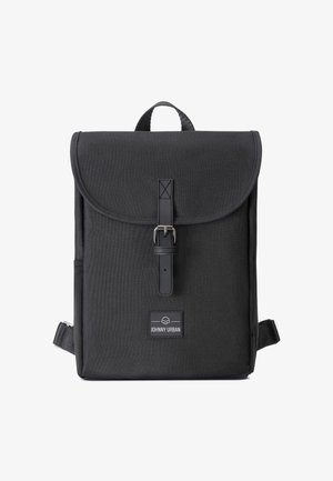 Mochila rectangular negra con solapa, cierre de correa con hebilla, asa superior y etiqueta frontal con la leyenda "Johnny Urban."